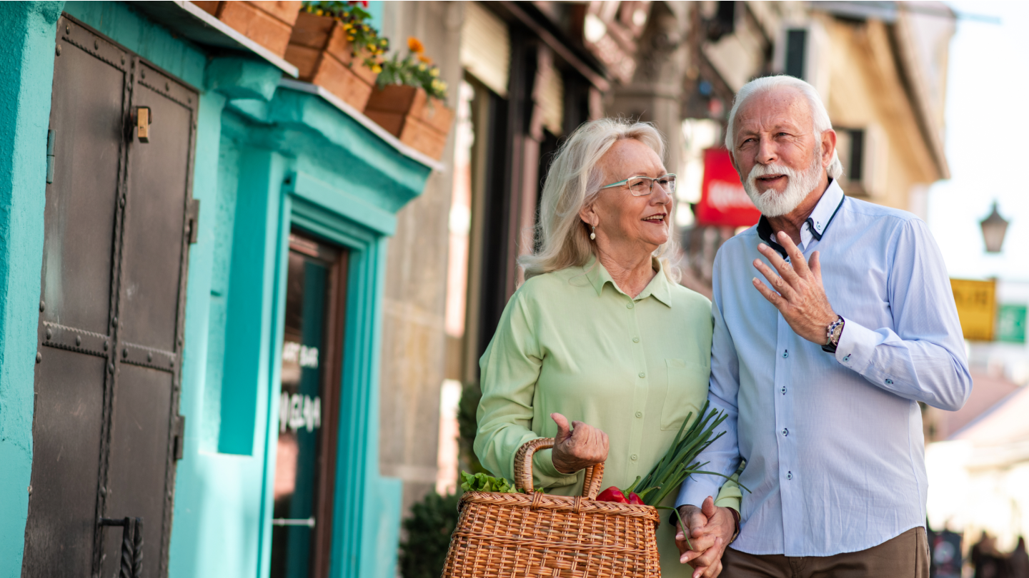 Older Handsome Man with Grey Hair and Beard is Walking Down the Streets with his Beautiful Female Partner with Grey Hair.